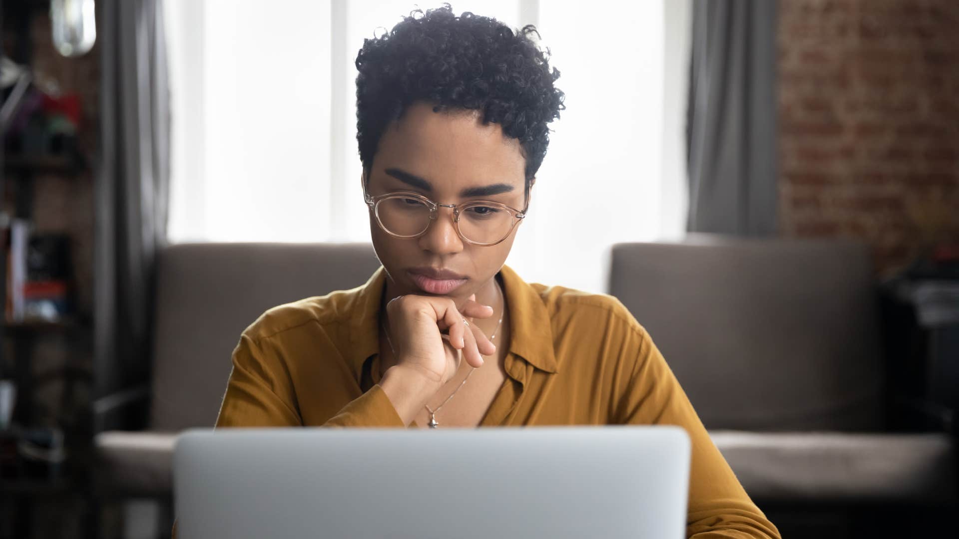 woman working on laptop while actively avoiding perfectionism