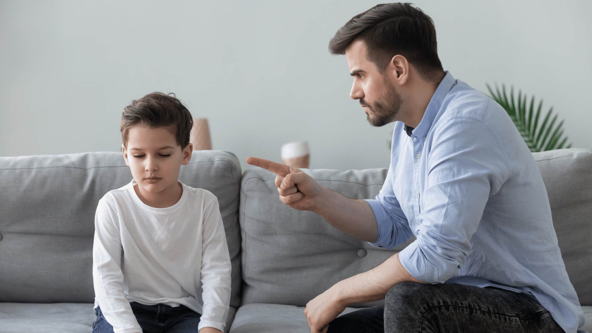 father yelling at son on couch