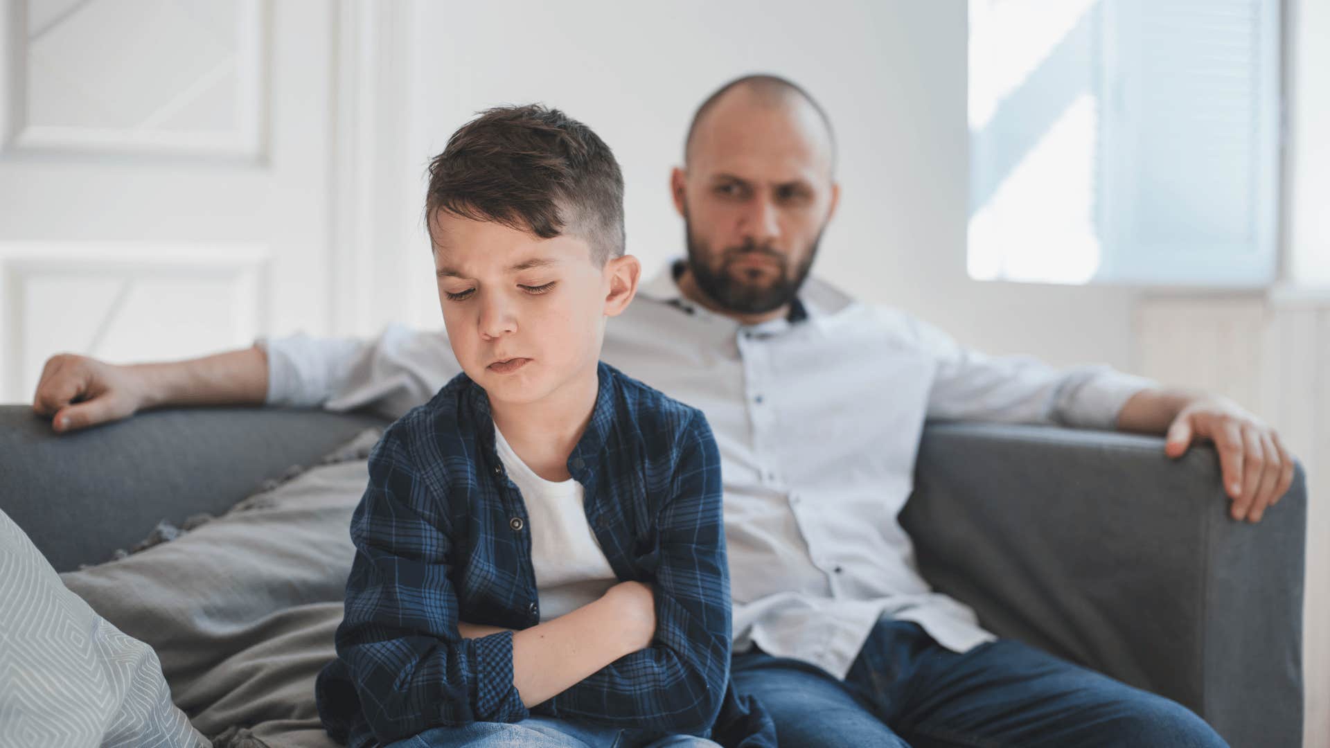 upset father sitting next to son