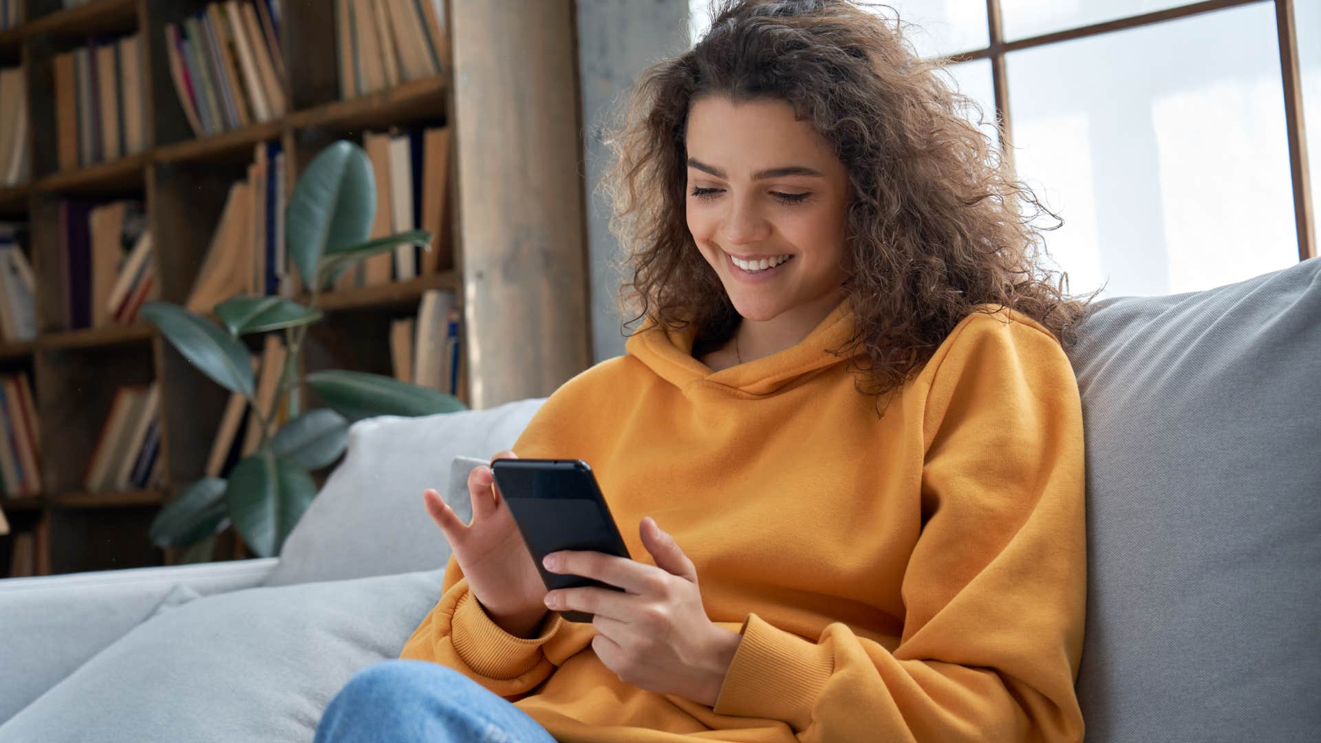 gen z woman looking at phone on couch bypassing traditional social media channels