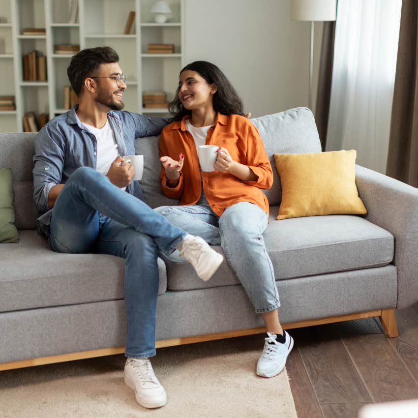 couple talking on couch quietly falling in love