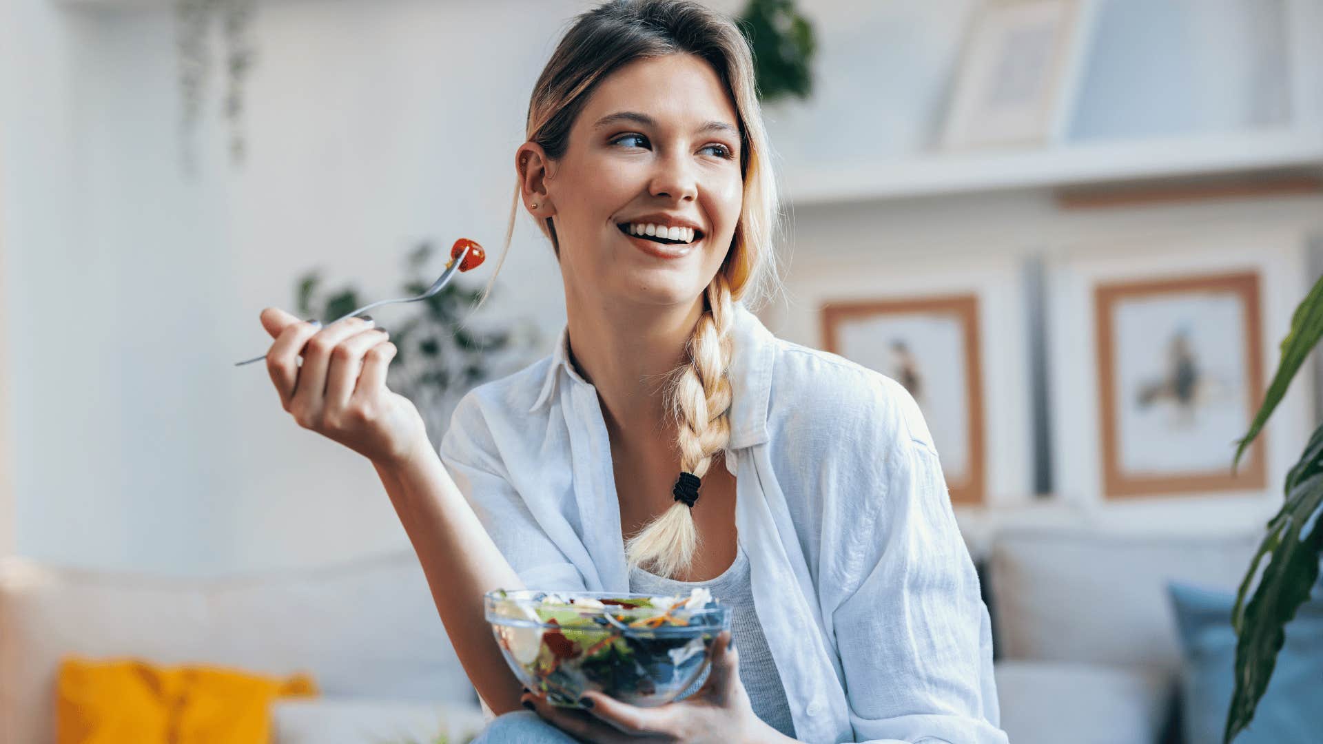 woman smiling and eating a salad