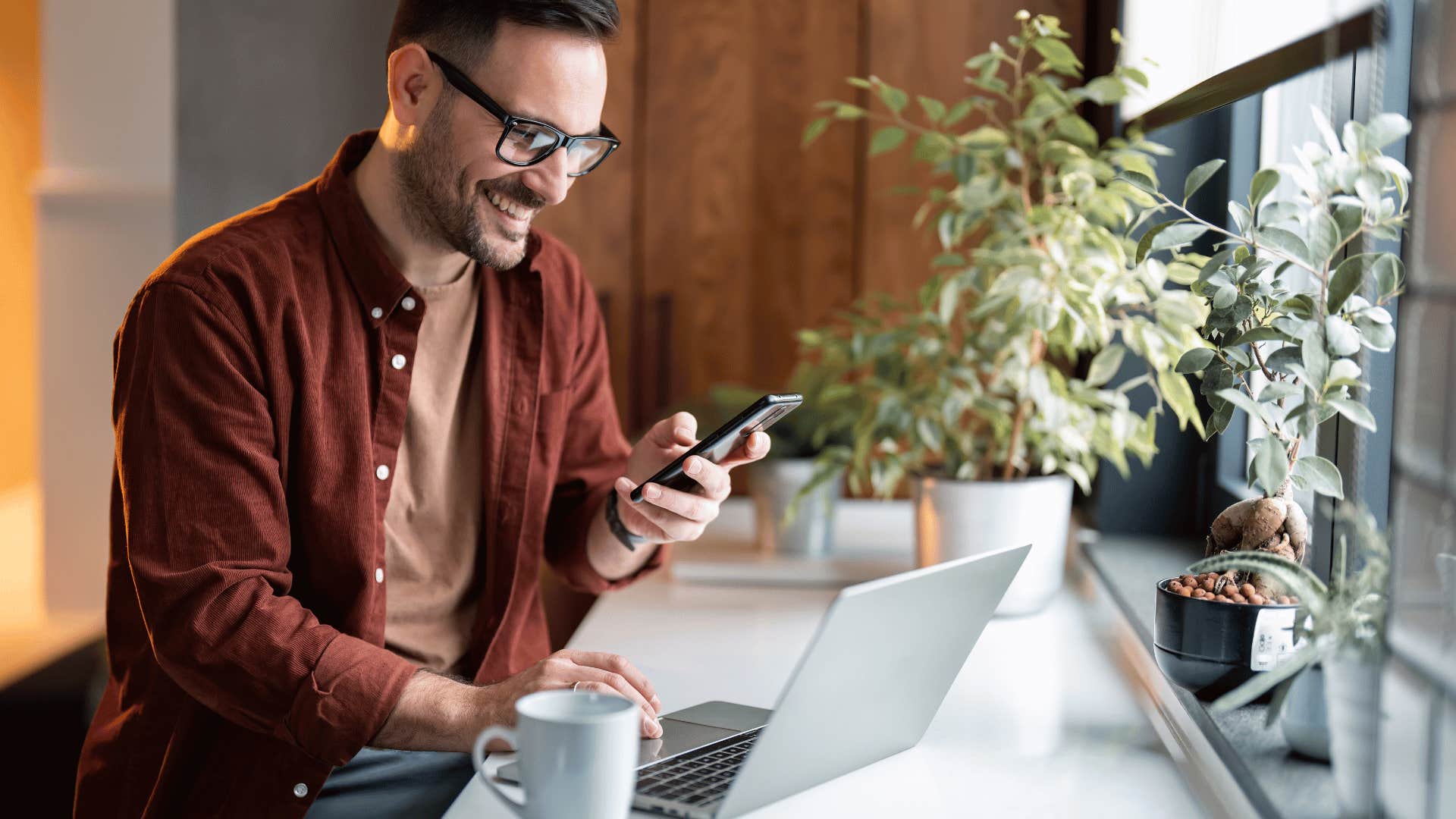 man smiling and working on laptop