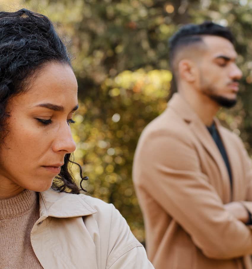 Unhappy woman turns away from defensive man