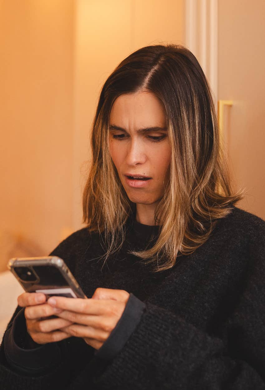 Woman reading a text asking that she return the money her brother gifted her