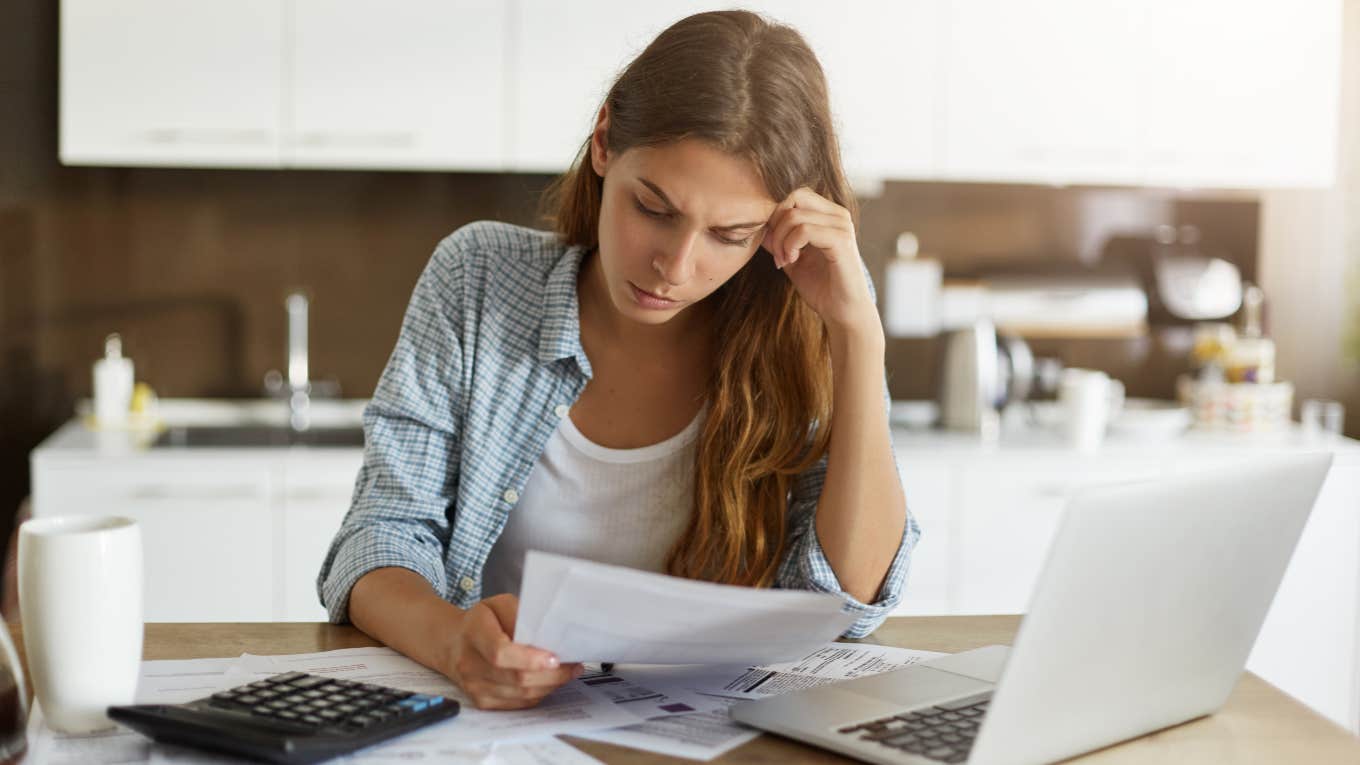 woman looking at bills so she can cancel subscriptions to save money to pay off debt