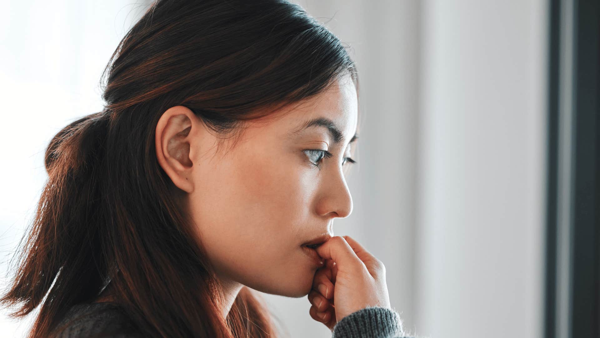 woman biting her nails thinking