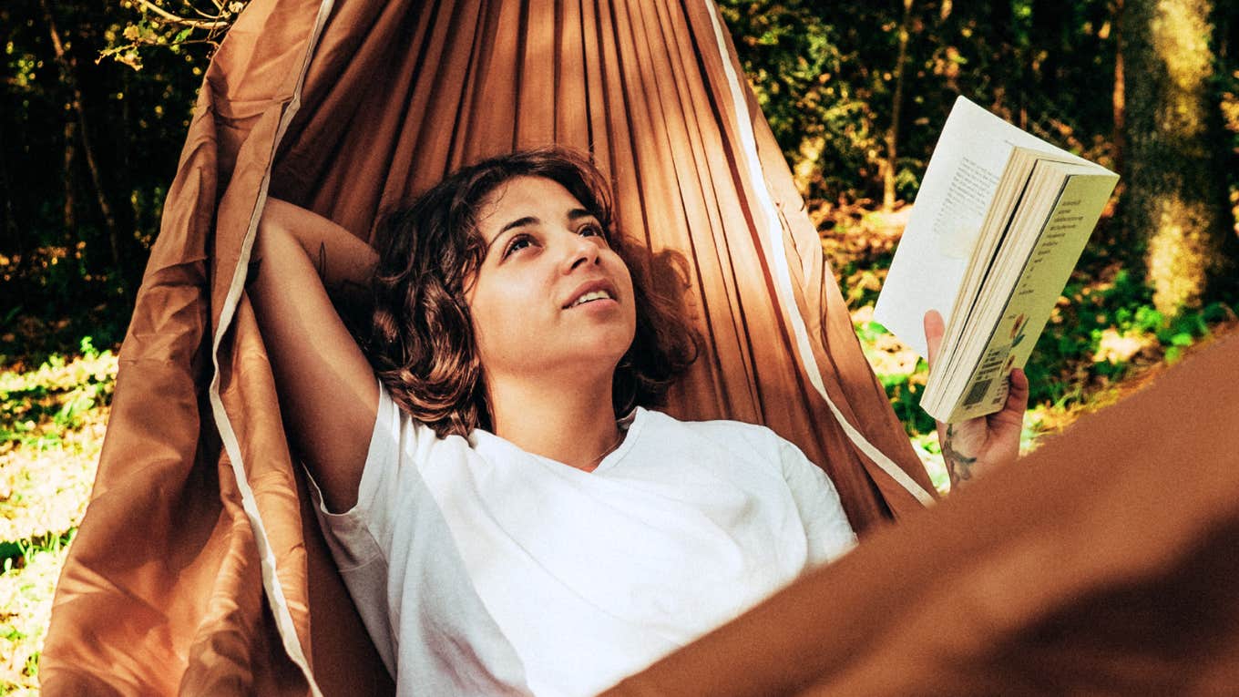 Low-Effort Habits That Instantly Make Life So Much Easier, According To Therapist Woman on a hammock with low-effort habits, making life so much easier.