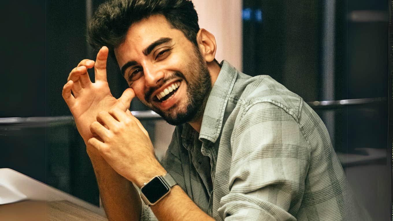 5 Subtle Clues That Signal Someone’s Totally Into You, According To Experts Flirty person giving clues that they are totally into you.