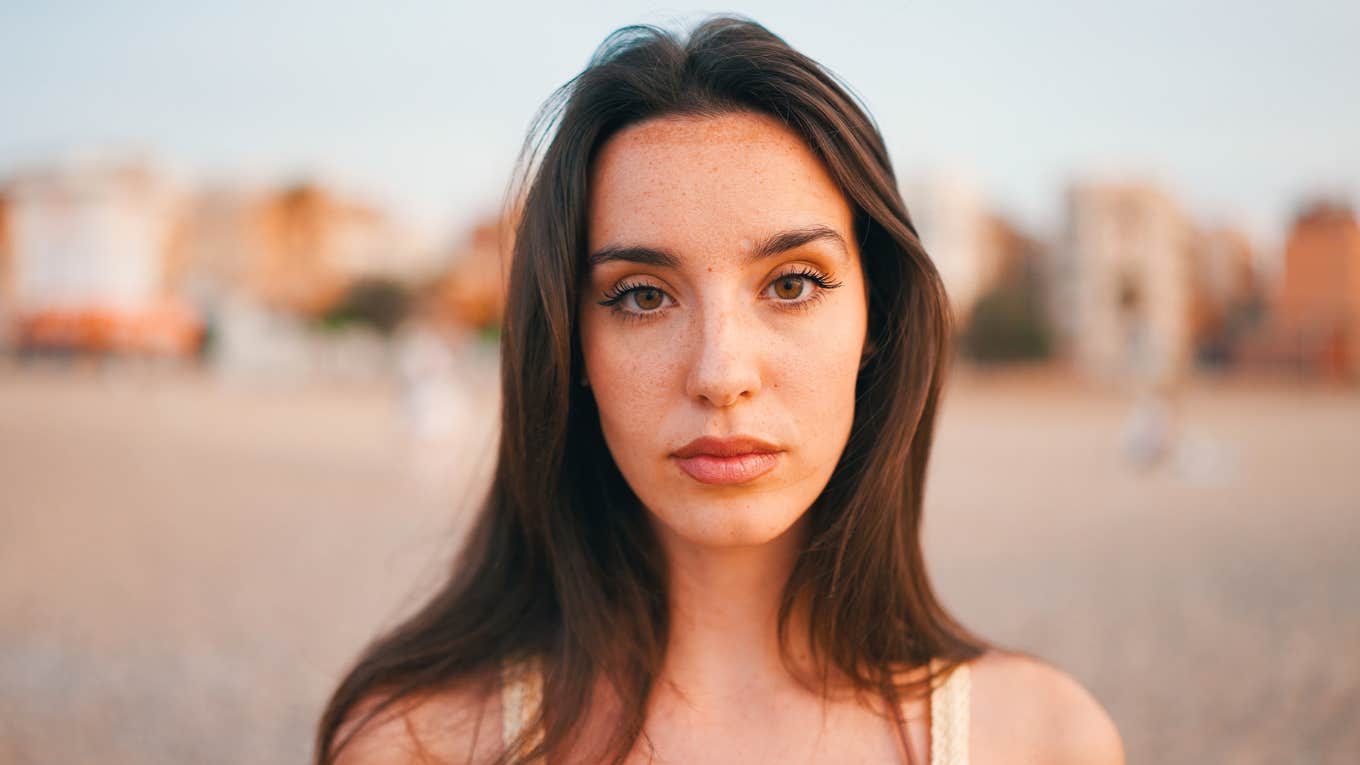 Painfully Clear Life Lessons People Forget Way Too Soon, According to Psychology serious woman with long hair thinking about life lessons