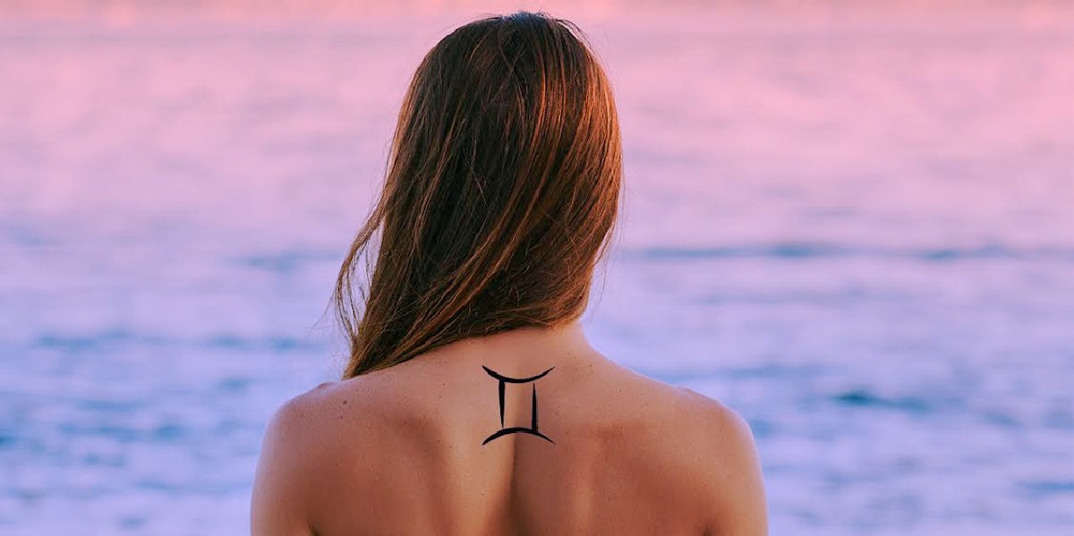 woman with gemini tattoo on back