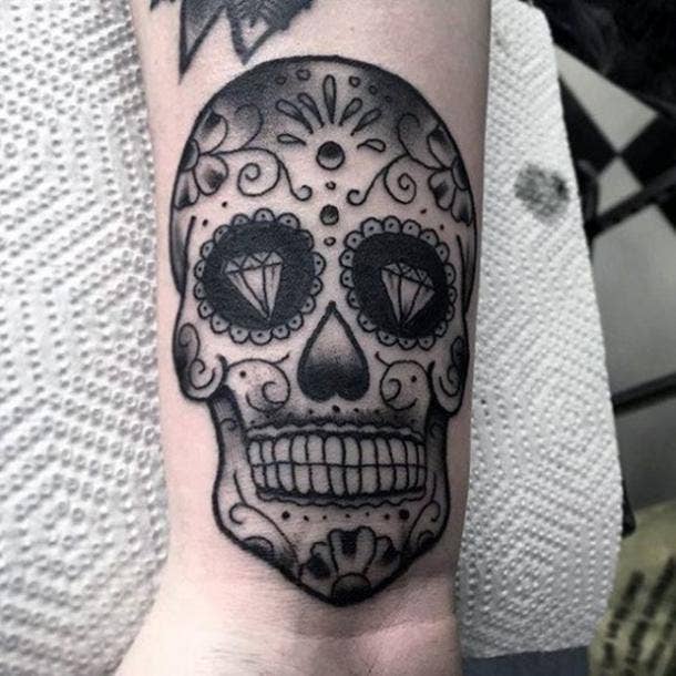 Black and grey skull tattoo on the hand
