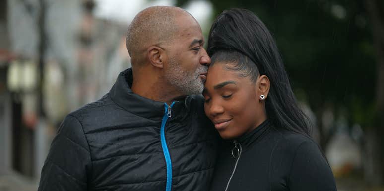 dad kissing teen daughter on forehead