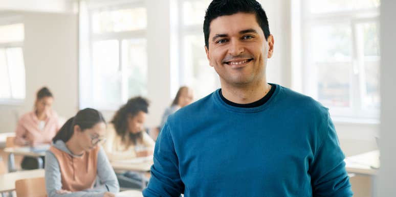 Male teacher wearing a t-shirt in his classroom. 