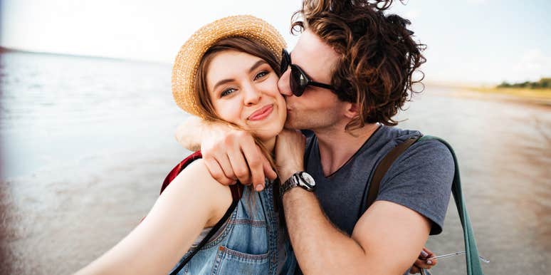 Man really into woman, kissing cheek.