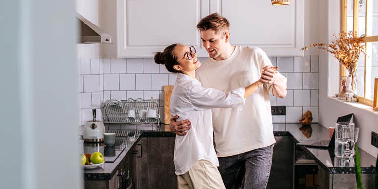 Married couple sharing small glimmer together in kitchen