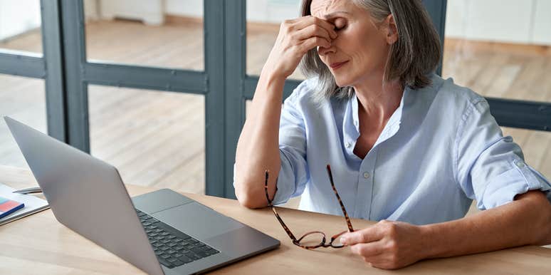 frustrated older woman sitting in front of laptop