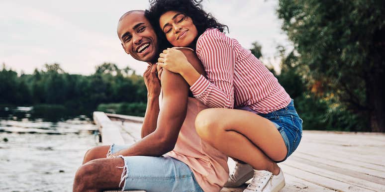 Compatible couple snuggling on a dock