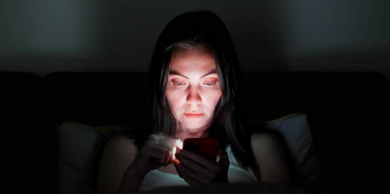 Woman looking at her exes social media at night before bed. 