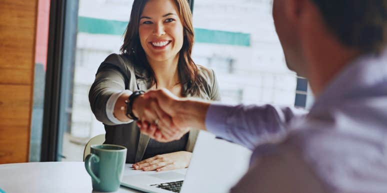 woman in office shaking hands with man 