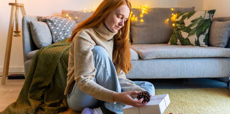 woman sitting on ground wrapping gift