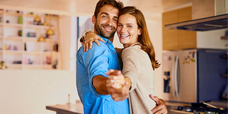 Man dancing with his partner in their kitchen.