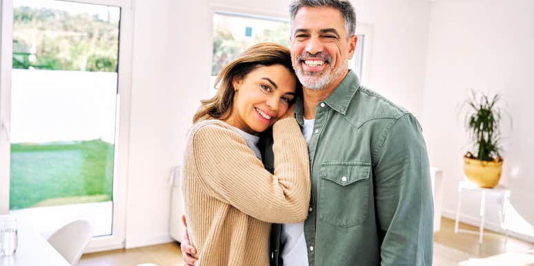 Mature couple in relationship posing in house.