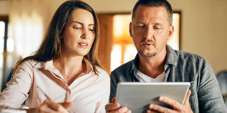 husband and wife looking at bank statement after depositing her work bonus