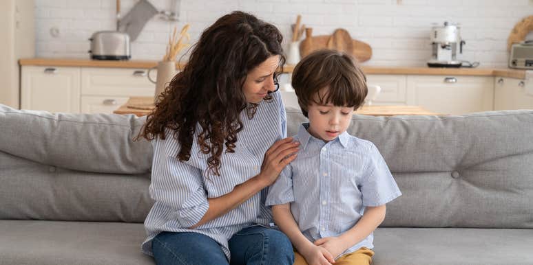 mom consoling her upset son while they sit on the couch