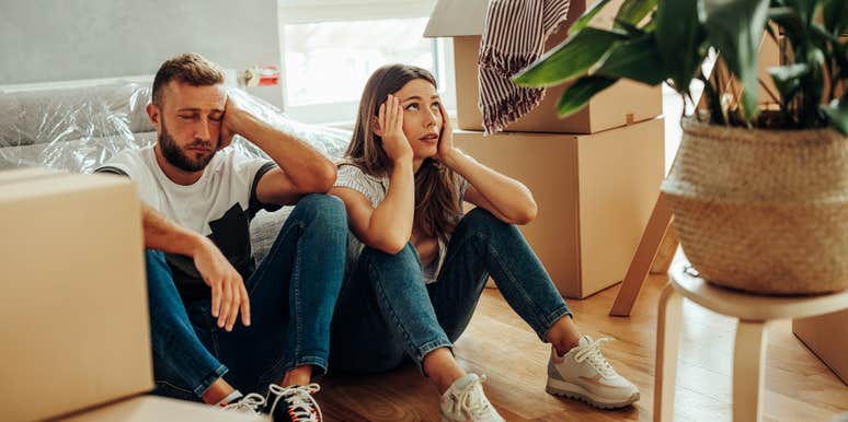 Upset couple surrounded by clutter in their home. 