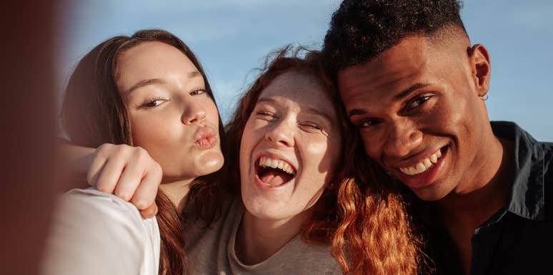 Three multicultural friends posing for the camera while hanging out together on a sunny day. 