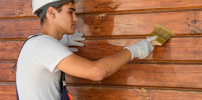 man painting exterior of a house