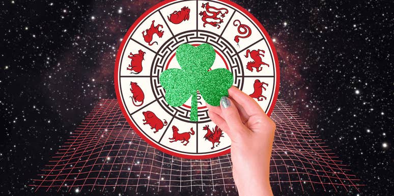 woman's hand holding shamrock for luck good fortune chinese zodiac signs week december 30-january 5