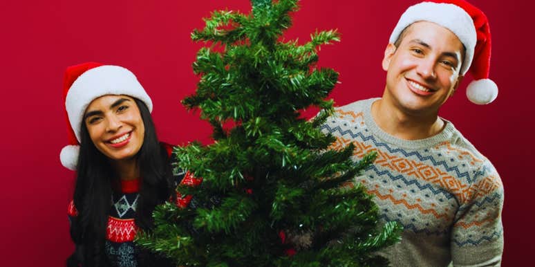 young happy couple with christmas tree 