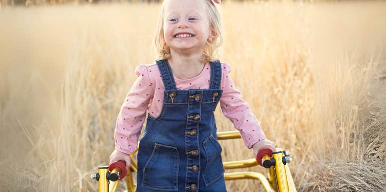 Smiling little girl using a walker