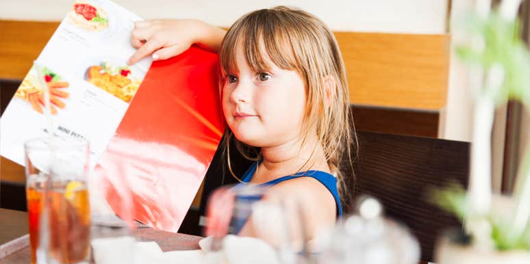 little girl pointing at what she wants on a restaurant menu