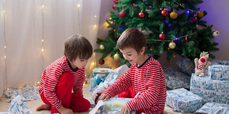 brothers opening gifts alone near Christmas tree