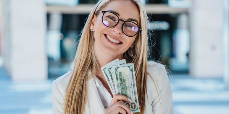 happy woman holding stack of cash