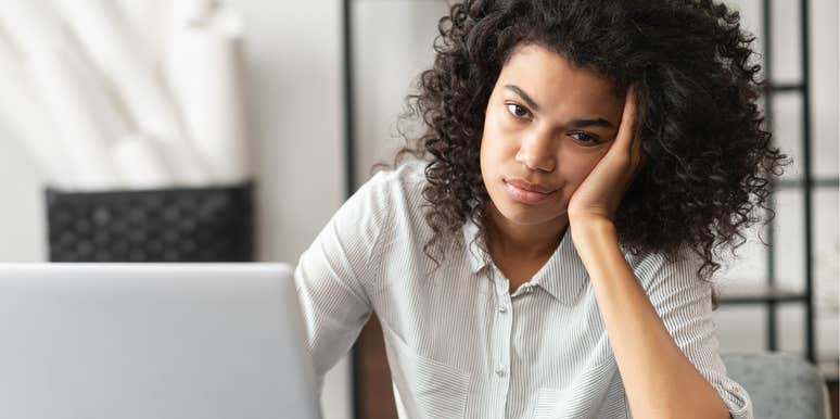 Woman looking annoyed sitting at her desk at work