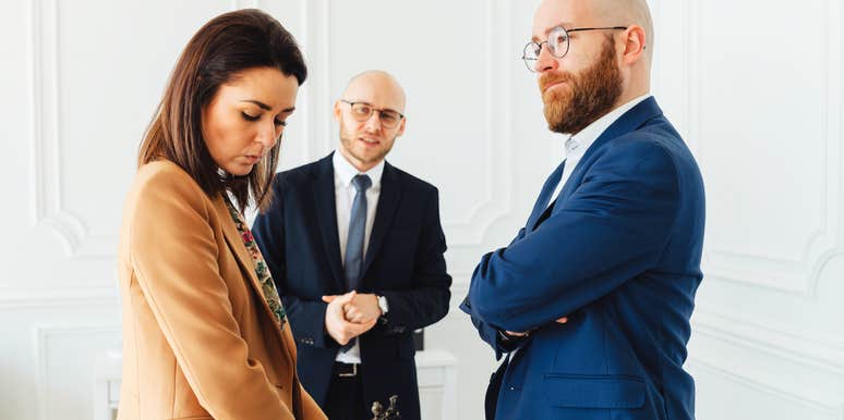 Woman looking down feeling anger, while husband looks satisfied. 