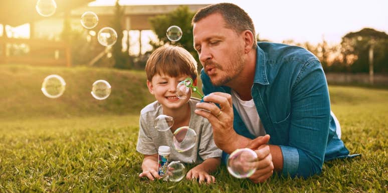 dad blowing bubbles with son