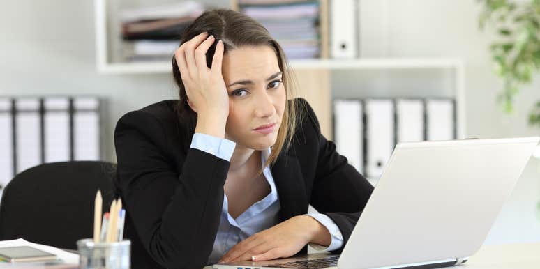 Woman sitting at desk after getting fired looking upset