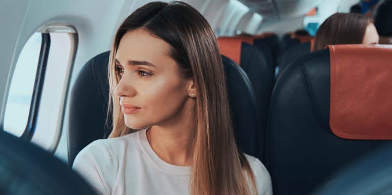 woman looking out window on plane 