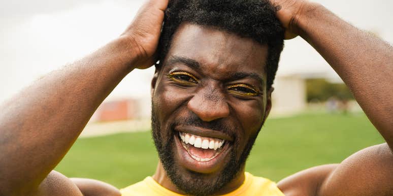 A man with a life filled with joy, wearing a yellow tank and smiling big