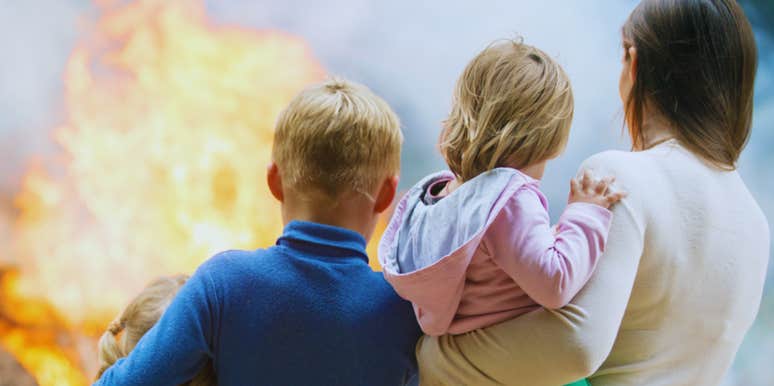 mom and children watching house burn