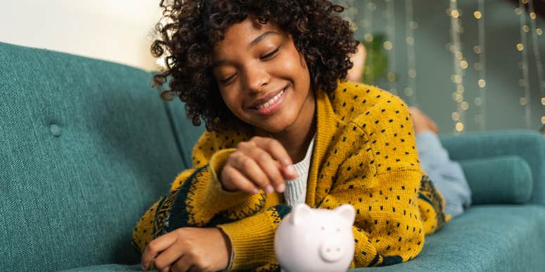 Woman putting change into a piggy bank