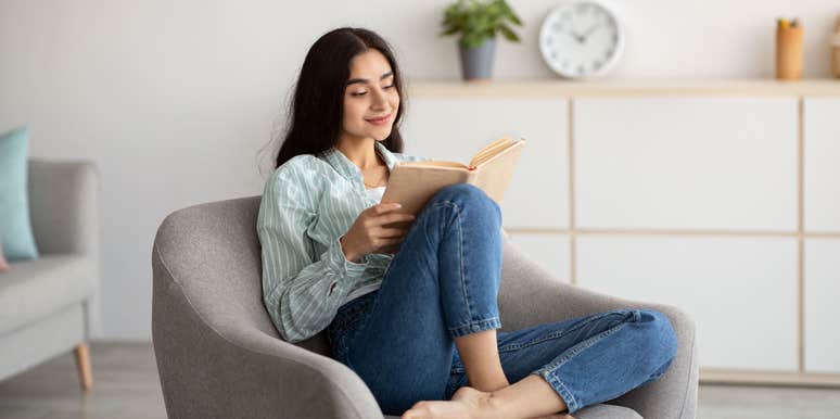 woman relaxing in chair while reading