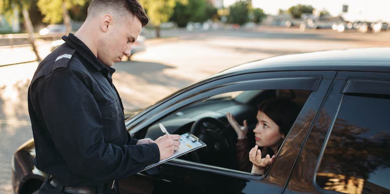 Police officer writing woman a ticket