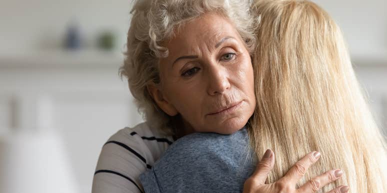 Older woman looking sad while hugging her adult daughter