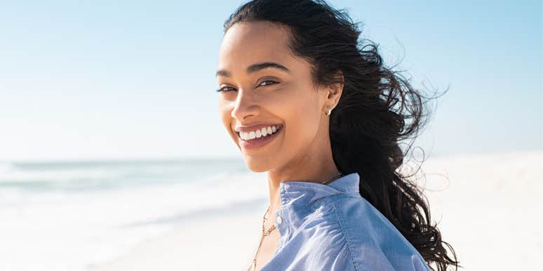 Woman smiling while standing on beach